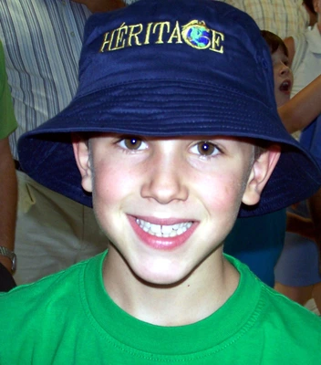 Élève avec un sourire et un chapeau d'école