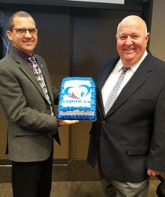 Simon Fecteau et Denis Labelle avec le gâteau qui présente le nouveau logo du CSPNE en décembre 017.